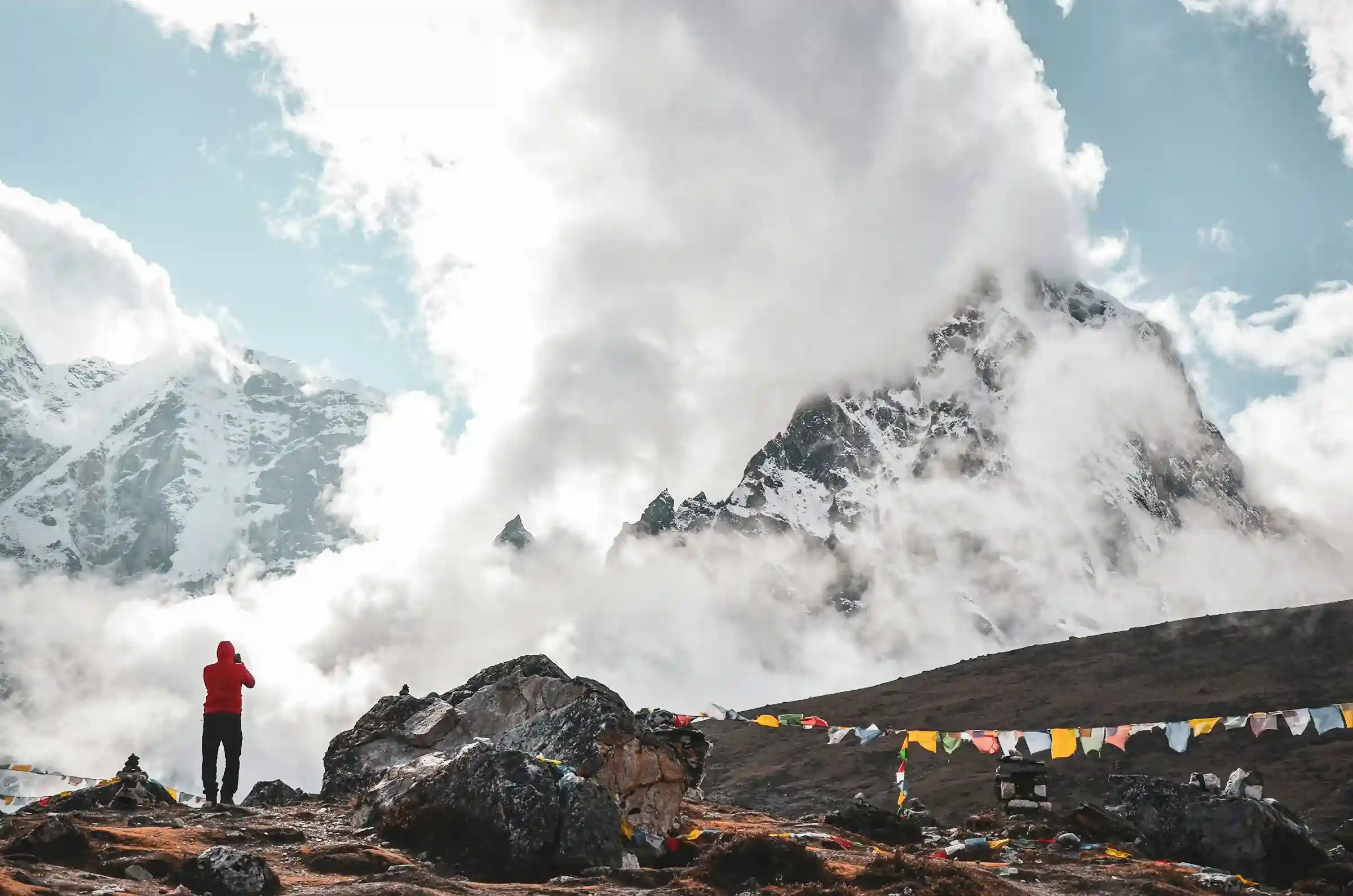 Trekker clicking picture of mountain while trekking in Nepal.